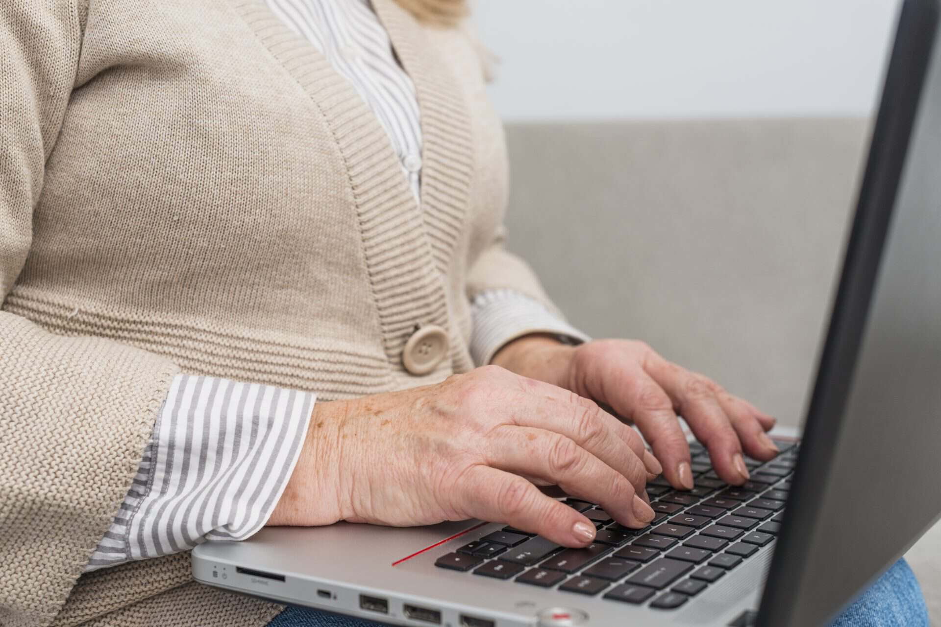 Oudere vrouw gebruikt laptop voor digitale zorg bij Vivent Langer Thuis.